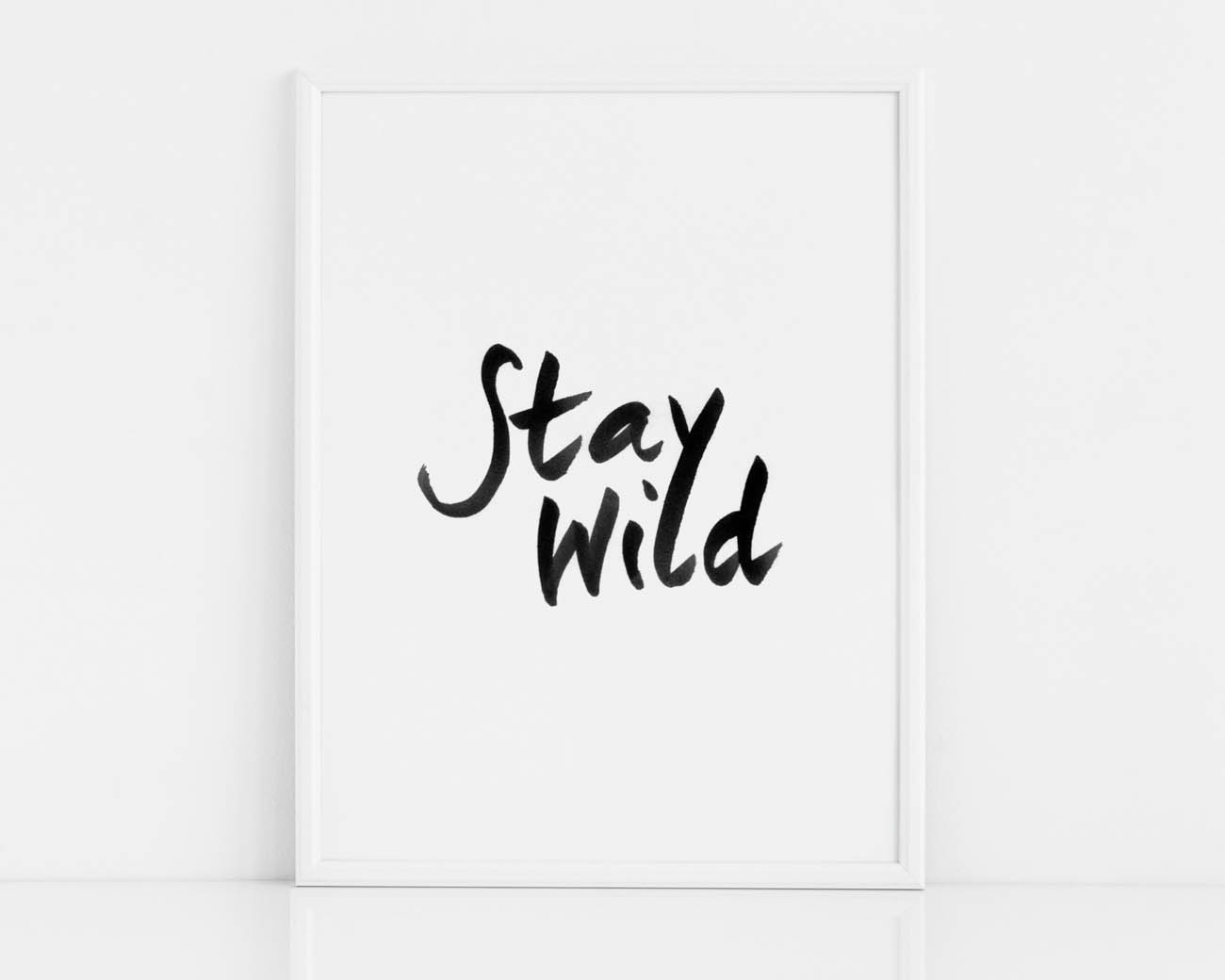 Czarno-biały plakat na ścianę z czarnym napisem STAY WILD