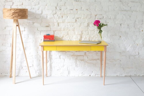 Minimalistyczne, funkcjonalne biurko z dyskretną szufladą idealnie pasuje do domowego biura żółte