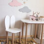 Biały stolik z drewnianymi nogami i krzesełko królik z białym siedziskiem i oparciem w kolorze białym.