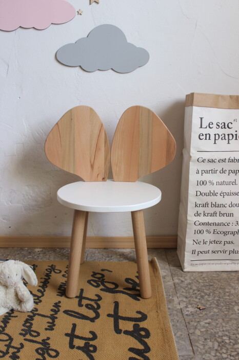 Drewniane małe krzesełko z uszami w kształcie myszki z białym siedziskiem i drewnianymi uszami.