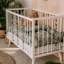 Białe drewniane łóżeczko niemowlęce ze szczebelkami