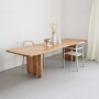 Masywny drewniany stół z blatem o zaokrąglonych rogach, na frezowanych drewnianych nogach