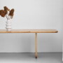 Masywny drewniany stół z blatem o zaokrąglonych rogach, na frezowanych drewnianych nogach
