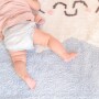 Błękitny dywan do pokoju dziecka, w białe drobne gwiazdki z jedną większą uśmiechniętą gwiazdką.