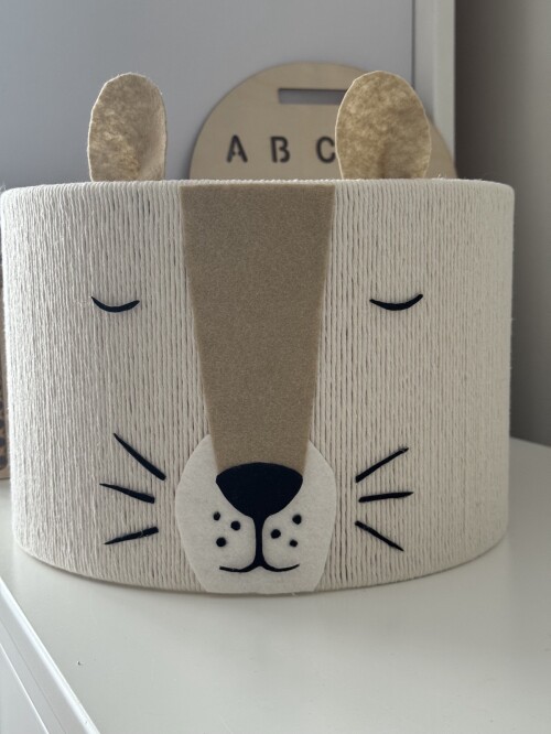 Lampa sufitowa ze sznurka w kremowym kolorze z twarzą lwa z filcu.