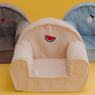 Sztruksowy mały fotelik dla małego dziecka lub starszego niemowlaka. Na foteliku wyhaftowany arbuz