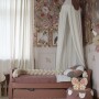 Lniany baldachim Cream Rose nad łóżkiem w pokoju dziewczynki z kwiatową tapetą